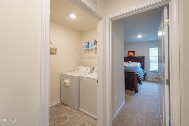 laundry room with independent washer and dryer and light colored carpet