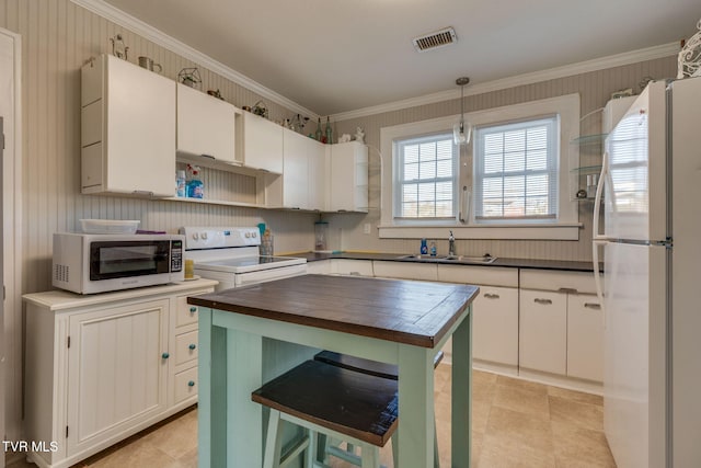 kitchen featuring decorative light fixtures, sink, white appliances, and white cabinets