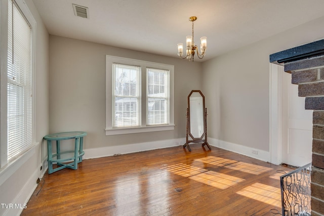 empty room featuring hardwood / wood-style floors and a notable chandelier