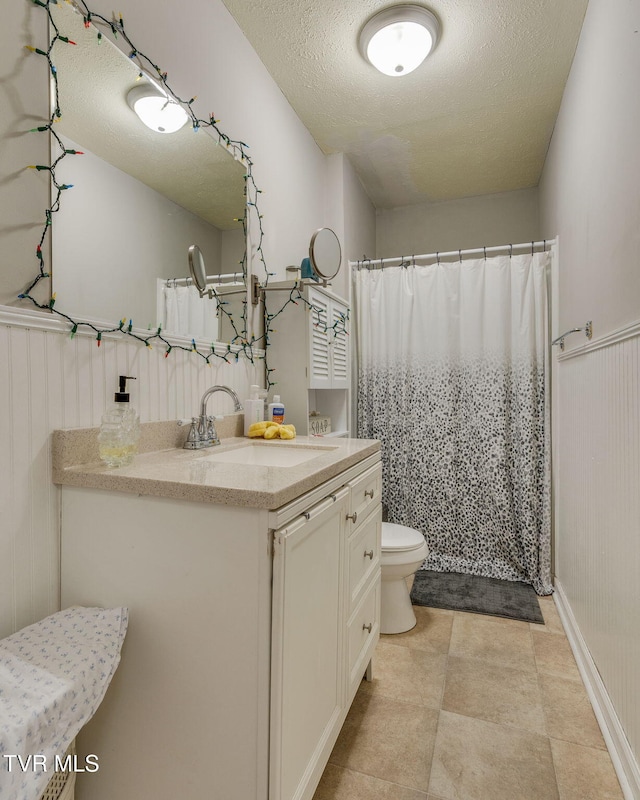 bathroom with toilet, vanity, and a textured ceiling