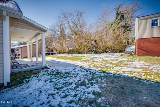 snowy yard featuring a patio