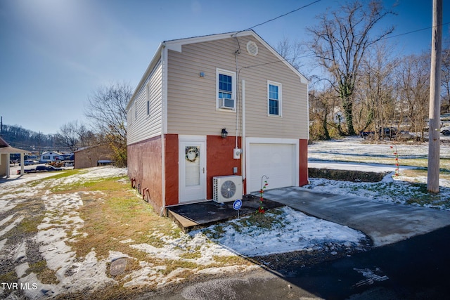 exterior space with ac unit and a garage