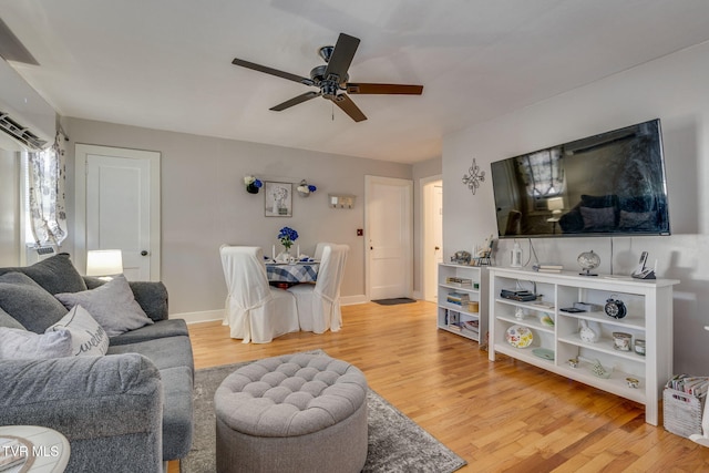 living room featuring hardwood / wood-style flooring, an AC wall unit, and ceiling fan