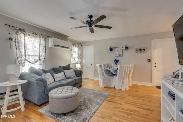 living room with light wood-type flooring, ceiling fan, and a wall mounted air conditioner