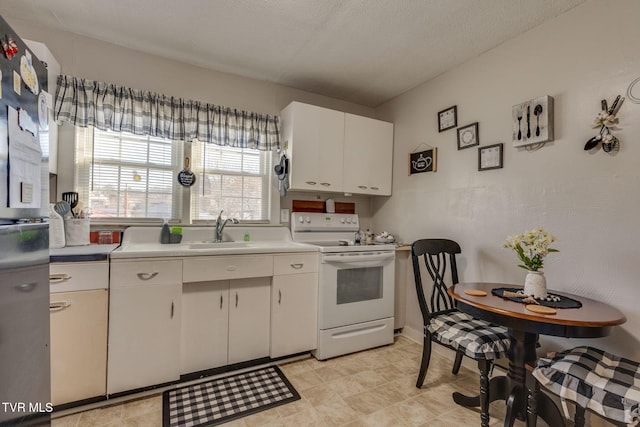 kitchen with electric stove, a textured ceiling, white cabinets, and sink