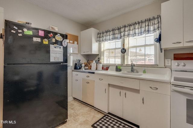 kitchen with black refrigerator, white cabinets, white electric range oven, and sink