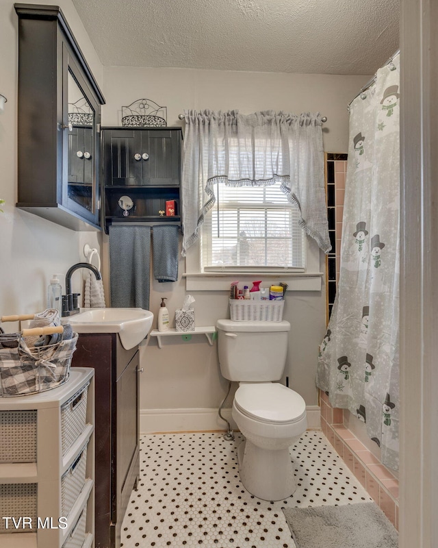 bathroom with curtained shower, a textured ceiling, toilet, and vanity