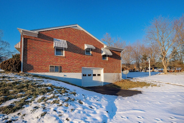 view of snow covered exterior featuring a garage