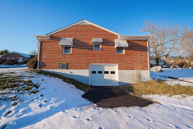 view of snow covered exterior featuring a garage