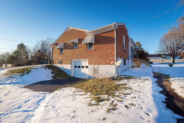 view of snow covered exterior featuring a garage