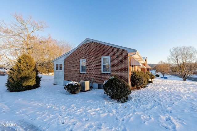 view of snow covered exterior featuring central AC