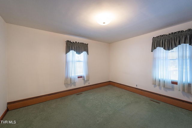 spare room with baseboard heating and carpet