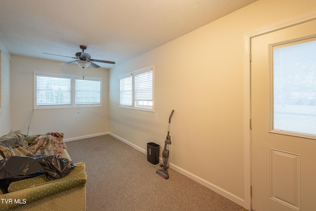 sitting room featuring a textured ceiling, ceiling fan, and carpet flooring