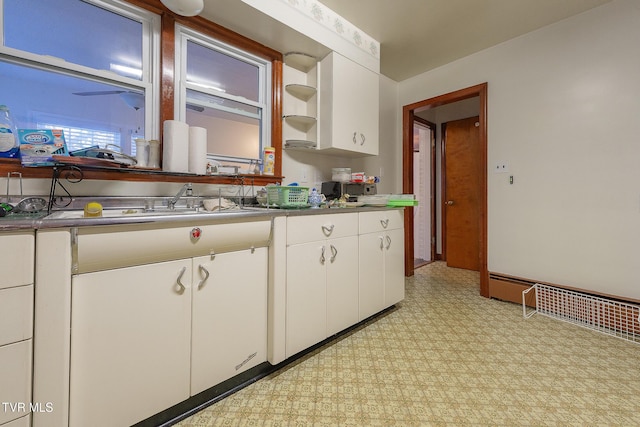 kitchen featuring white cabinets and a baseboard radiator