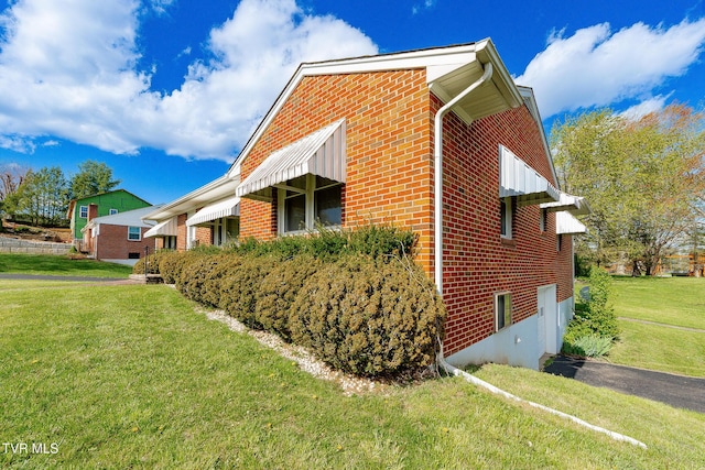 view of side of home featuring a yard and brick siding