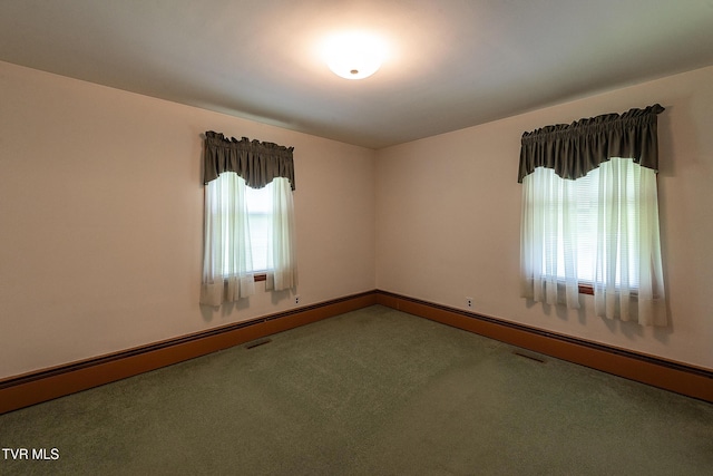 unfurnished room with carpet floors, baseboards, and visible vents