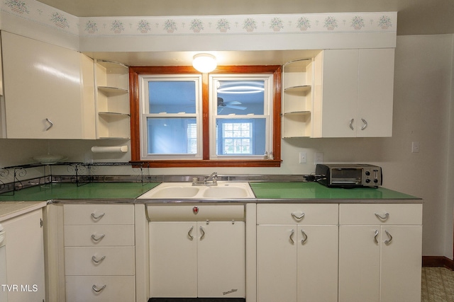 kitchen featuring a sink, white cabinets, open shelves, and a toaster