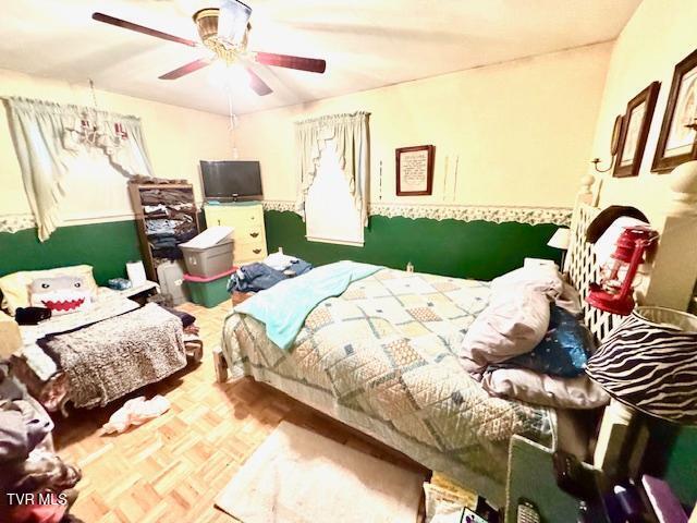 bedroom with ceiling fan and parquet floors