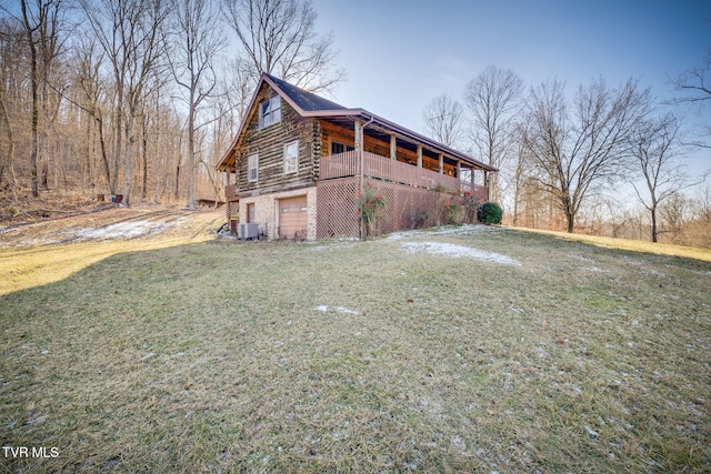 view of side of property with a garage, cooling unit, and a lawn