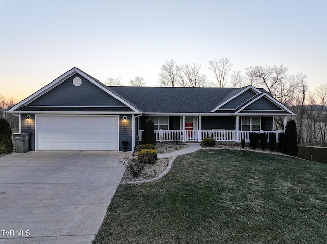 ranch-style house featuring a porch, a garage, and a lawn