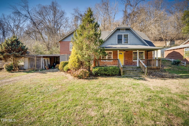 view of front of house with covered porch, an outbuilding, and a front yard