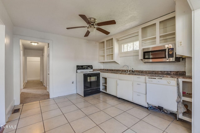 kitchen with light tile patterned floors, white appliances, white cabinetry, and sink