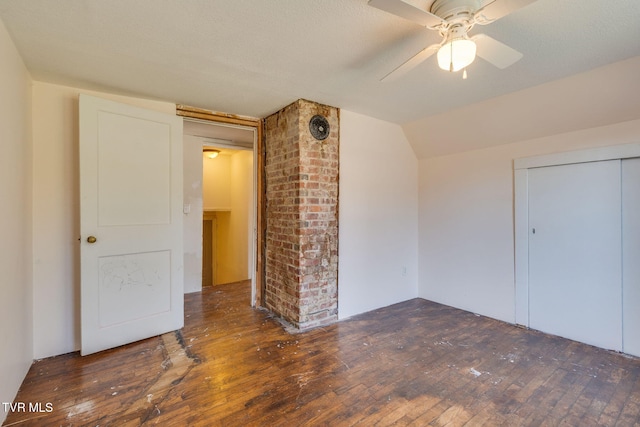 unfurnished bedroom featuring dark hardwood / wood-style flooring, a closet, ceiling fan, and lofted ceiling