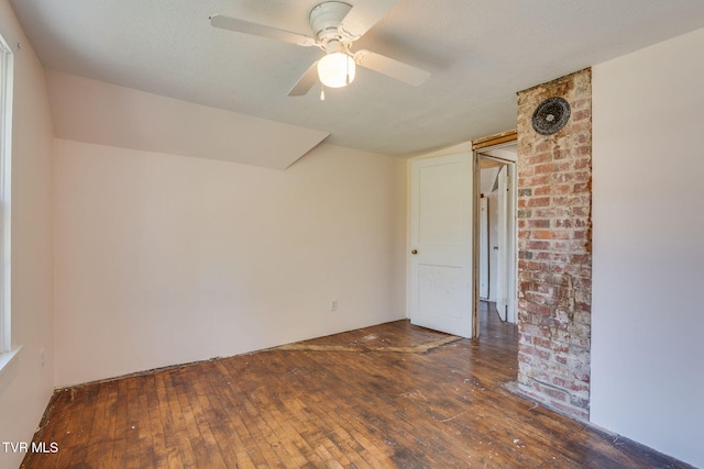 empty room with a textured ceiling, ceiling fan, and dark wood-type flooring