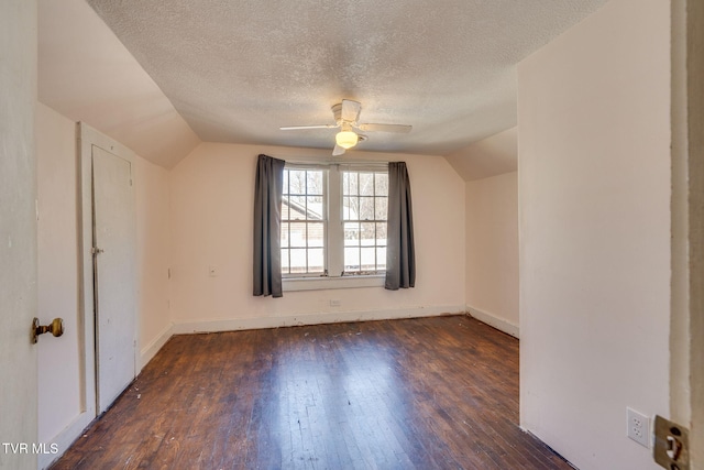 bonus room with a textured ceiling, ceiling fan, dark hardwood / wood-style floors, and vaulted ceiling