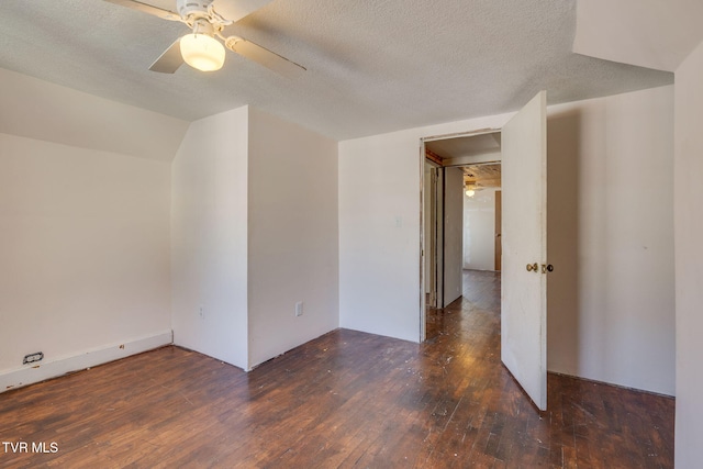 spare room with a textured ceiling, lofted ceiling, ceiling fan, and dark hardwood / wood-style floors