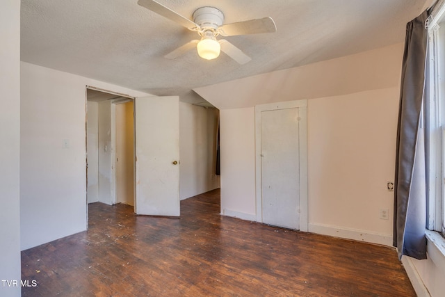 bonus room with a textured ceiling, dark hardwood / wood-style flooring, and ceiling fan