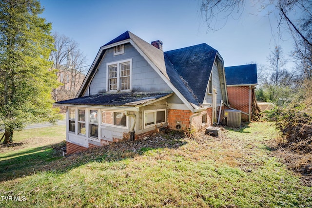 rear view of house with a yard and cooling unit