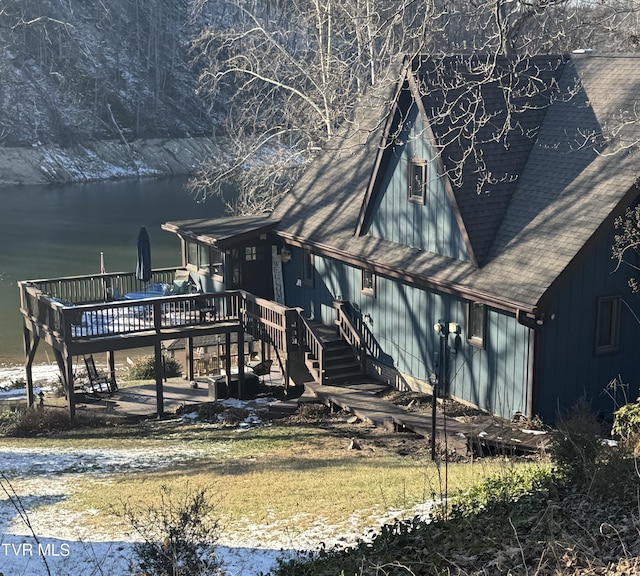 rear view of house featuring a deck with water view