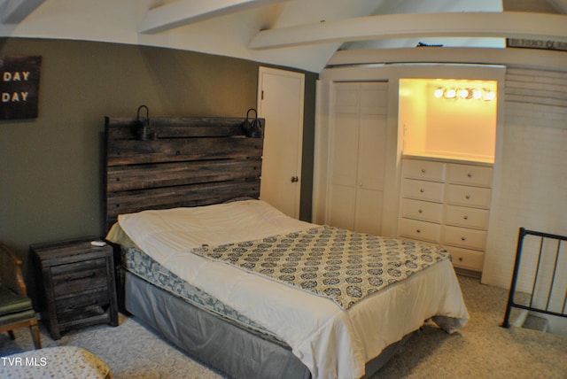 carpeted bedroom with a closet and beam ceiling