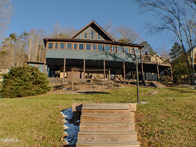 back of property featuring a lawn and a wooden deck