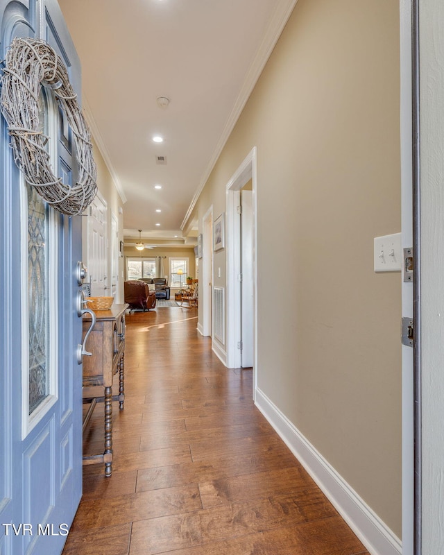 hallway with dark wood-type flooring and crown molding