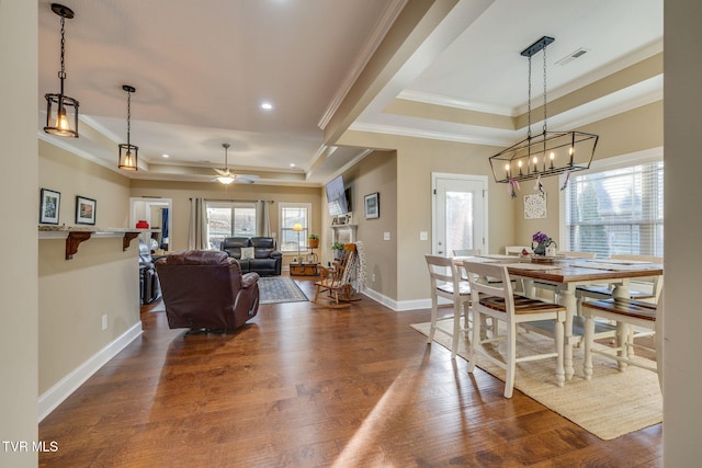 dining space featuring crown molding, ceiling fan, a tray ceiling, and hardwood / wood-style floors