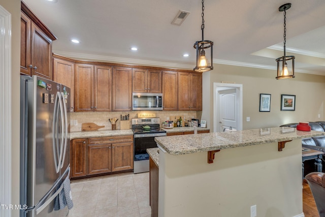 kitchen featuring appliances with stainless steel finishes, pendant lighting, light stone counters, and a kitchen bar