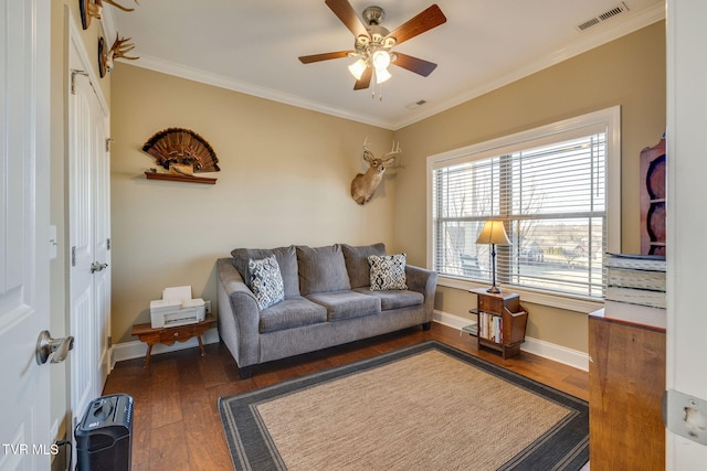 living room with dark wood-type flooring, ornamental molding, and ceiling fan