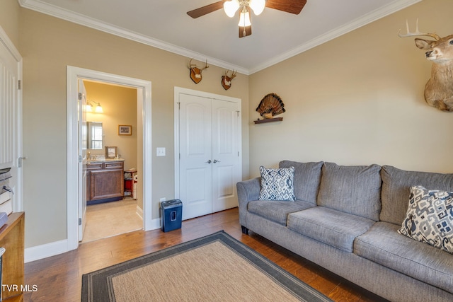 living room with crown molding, dark wood-type flooring, and ceiling fan