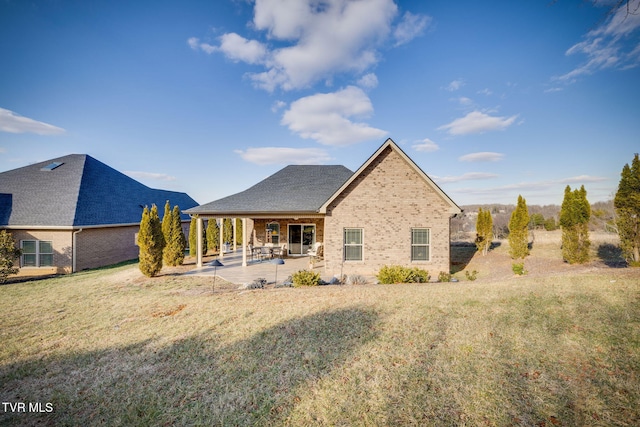 back of property with a yard and a patio area