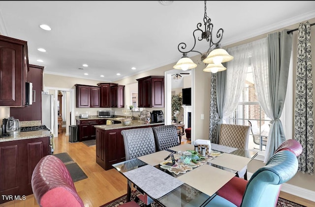 dining space featuring light hardwood / wood-style floors, crown molding, and a chandelier