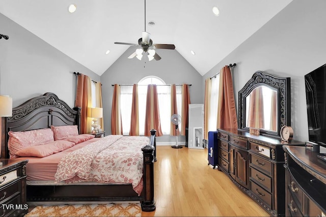 bedroom with ceiling fan, vaulted ceiling, and light wood-type flooring