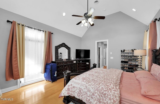 bedroom with ceiling fan, light wood-type flooring, and vaulted ceiling