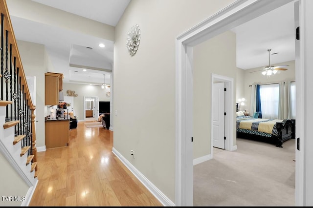 hall with a towering ceiling and light hardwood / wood-style floors