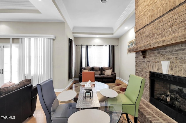 dining room featuring crown molding, light hardwood / wood-style flooring, and a brick fireplace