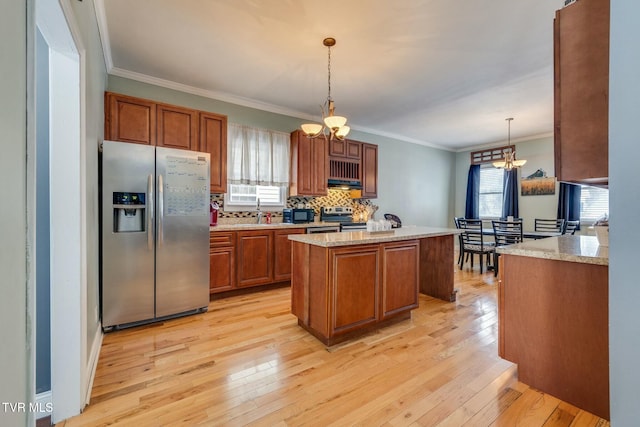 kitchen with crown molding, light hardwood / wood-style flooring, a kitchen island, pendant lighting, and stainless steel appliances