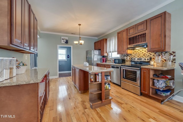 kitchen featuring decorative light fixtures, a center island, light hardwood / wood-style floors, and appliances with stainless steel finishes