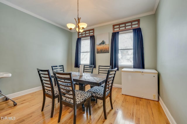 dining room with ornamental molding, a chandelier, and light hardwood / wood-style floors