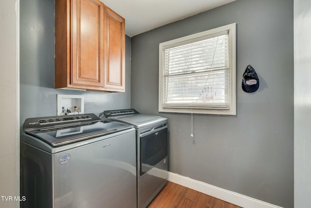 washroom with cabinets, hardwood / wood-style floors, and separate washer and dryer